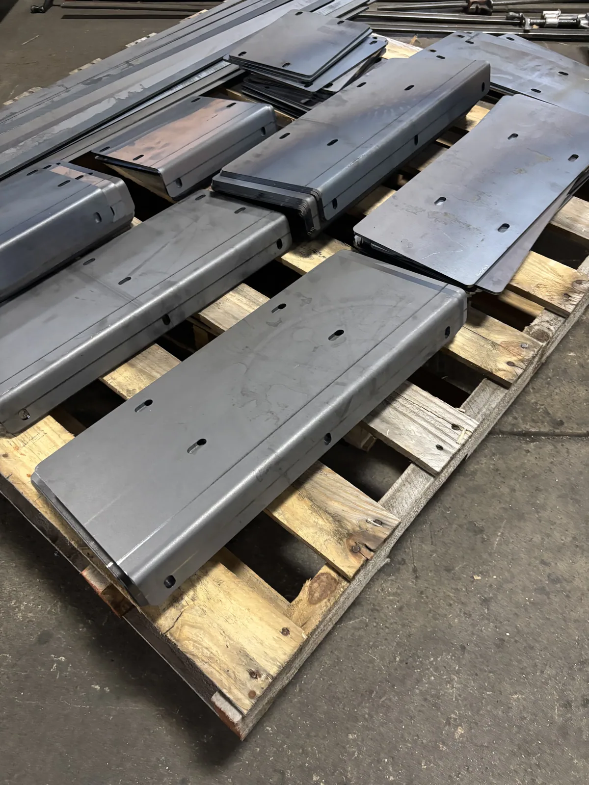 Formed steel brackets stacked neatly on a pallet