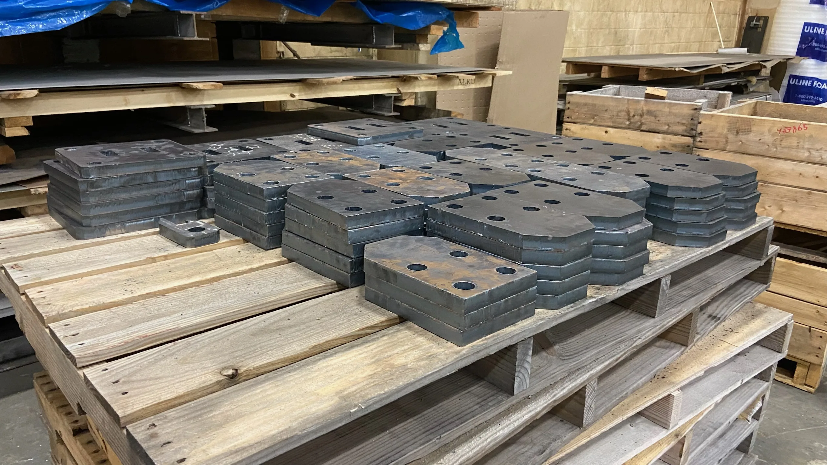 Stacks of laser-cut steel parts in the Ahner shop